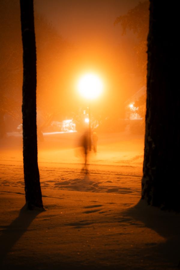 Ghost figure in orange snowstorm at night